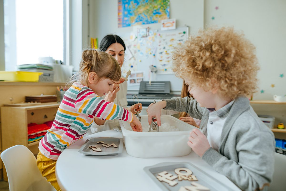 learning-play-activities-in-kindergarten-or-daycar-2022-08-01-01-15-33-utc Two children playing with their teacher at school