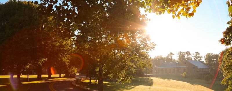 A landscape photo featuring a sunny morning view of University Point from the road leading onto Concord's campus.