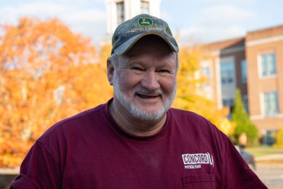 A photo of Steven Wood featuring an Autumn backdrop, highlighted by orange Fall foliage.