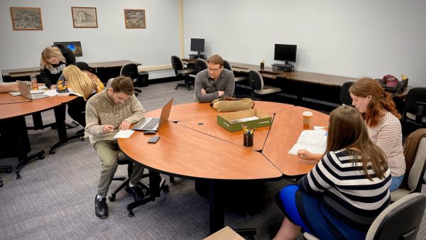 A group of students talking to Tina Powell in the writing center