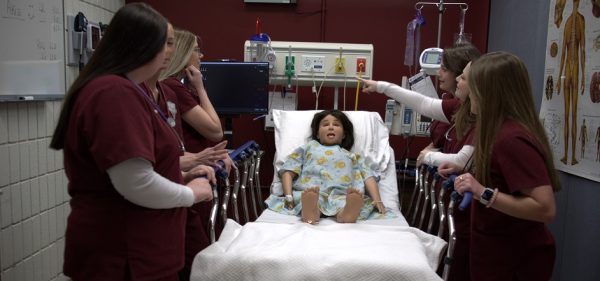 Nursing students work together during a pediatric training scenario.