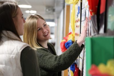 Education students decorating a classroom bulletin board