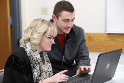 Two students looking at a laptop