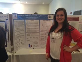 A psychology student standing next to her poster presentation at the Concord University Research Festival