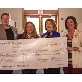 A photo of Caitlin Thompson, Kayla Karr, Kendra Boggess, and Sarah Turner holding a giant check worth $5000 from the Enterprise Holdings Foundation to the Concord University Gap Fund.