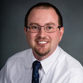 Jacob-Womack-2 A photo of Dr. Jacob Womack in front of a neutral background