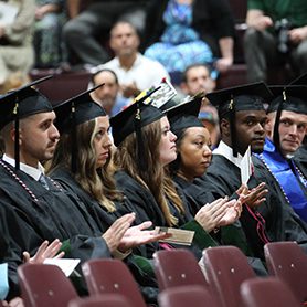A photo of Concord University graduates clapping during the commencement ceremony