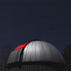 A photo of the Concord University Observatory under a dark, starry sky