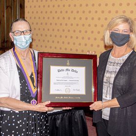 Dr. Charlotte Davis, Associate Professor of Management, left, and Dr. Susan Robinett, Department of Business Chair, right, receive the charter as co-advisors of the Omicron Psi Chapter.
