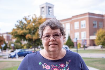 A photo of Sheila Pettrey with Concord's bell tower in the background.