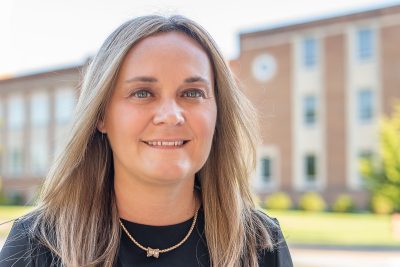 A photo of Amanda Cooper in front of Marsh Hall at Concord University