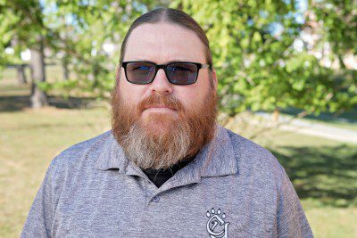 A photo of Bill Fraley, Concord University Student Support Service's Educational Counselor, with the Athens campus greenery in the background.