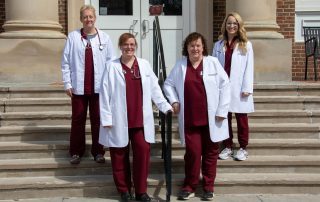Department of Nursing Faculty stand together on the front steps of the J. Frank Marsh Library on Concord University's main campus. Faculty members include (from left to right) Professor Danita Farley, Dr. Michele Holt, Dr. Martha Snider, and Professor Amanda Nichols.