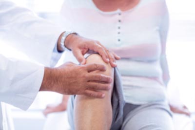 A physical therapist touching someone's knee