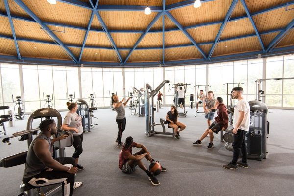 A group of students talking and working out in the Concord University Fitness Center