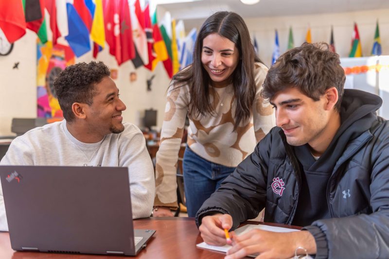 Three students working on homework while talking and laughing in the Office of Multicultural Affairs, which is located in the Jean and Jerry Beasley Student Center