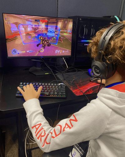 An Esports camper playing a game on a computer in the Concord Esports facility