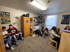 Students inside of a room of the towers residence halls. The beds are bunked, and you can see their closets, dressers, and desks