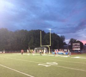 Students playing intramural soccer as the sun sets
