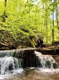 Two students at a waterfall at Brushcreek Falls State Park