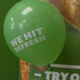 A green balloon that says We Hit Refresh