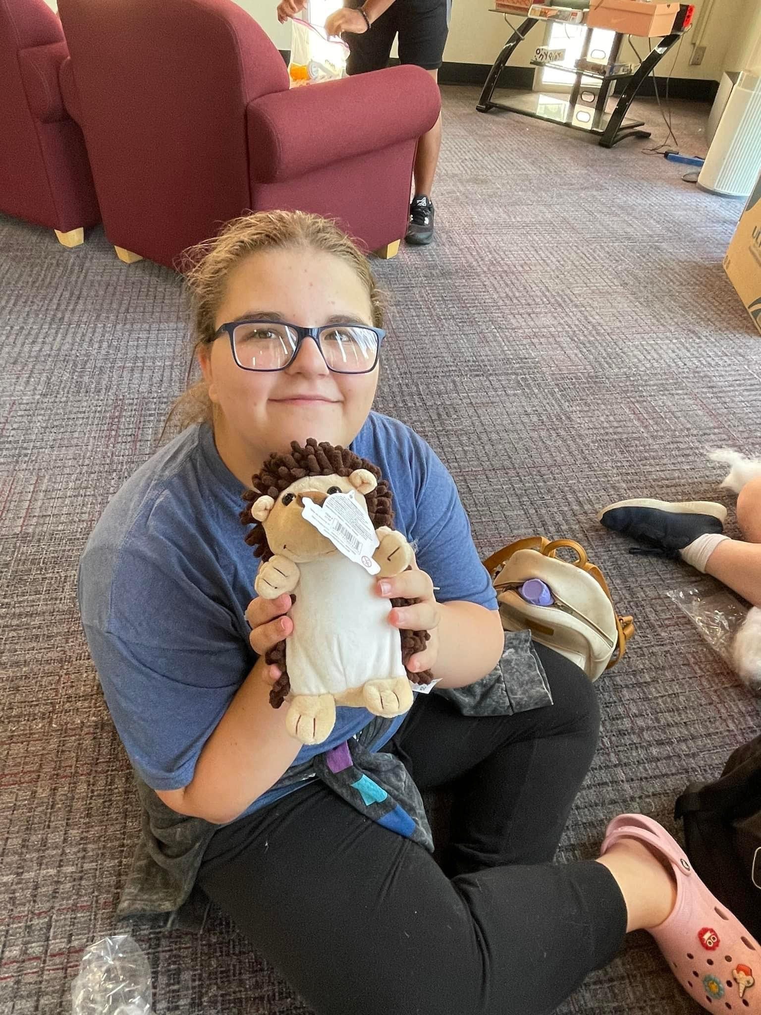 An Upward Bound student holding a stuffed animal