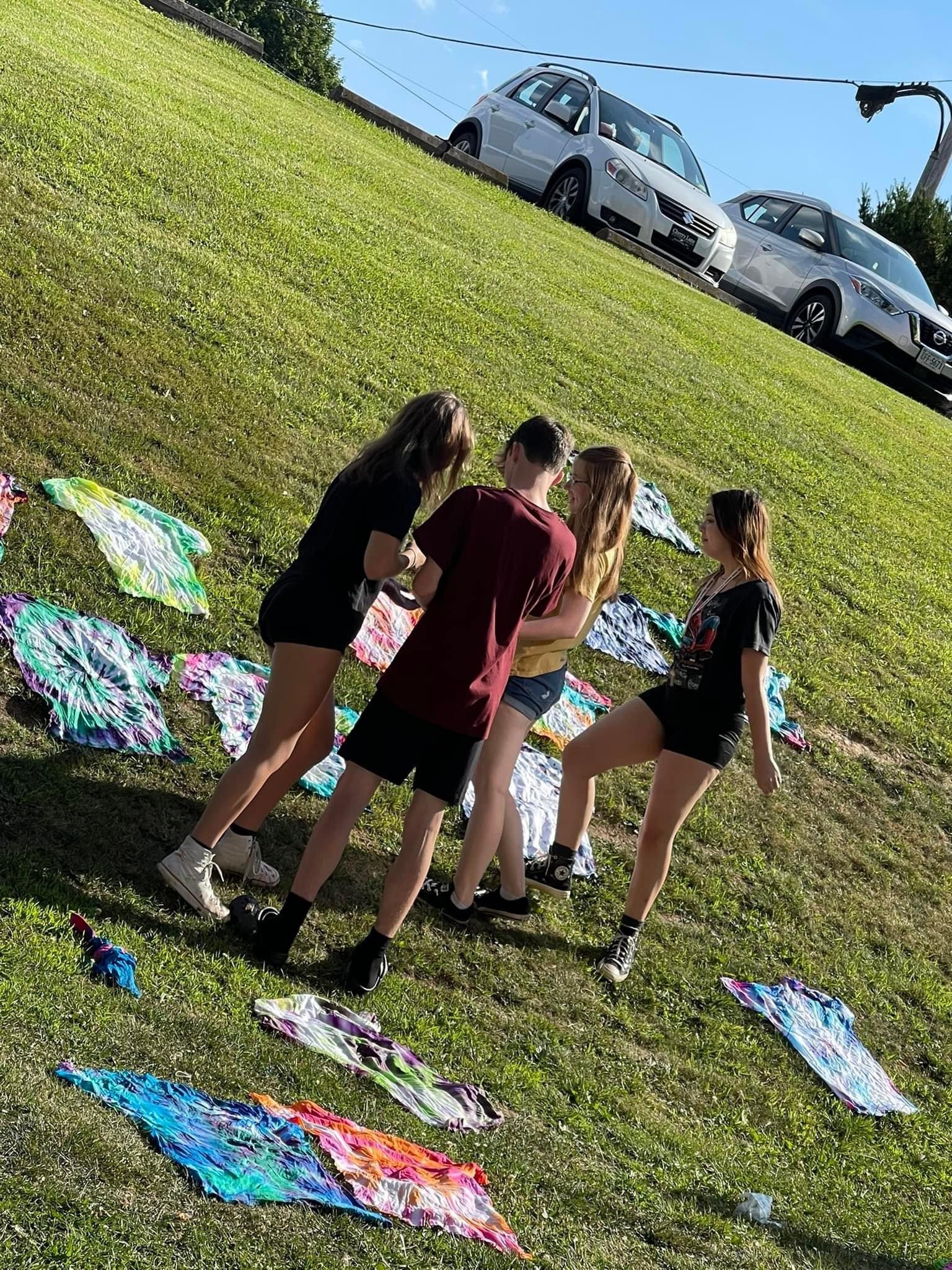 Four Concord University Upward Bound students tie dyeing shirts