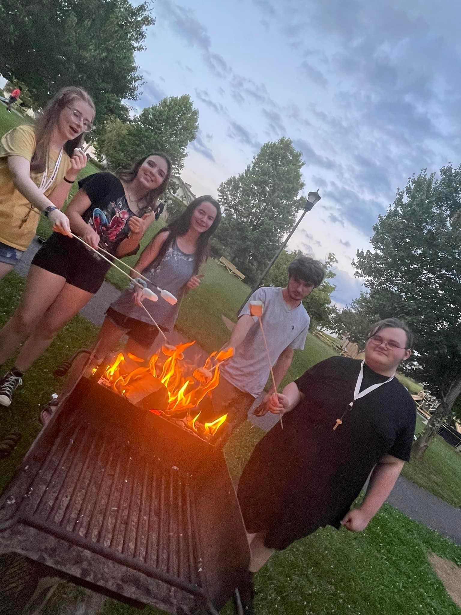 Five Concord University Upward Bound students roasting marshmallows